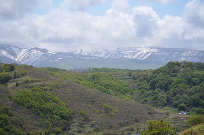 Scenic view of mountains against cloudy sky