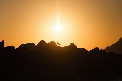 Scenic view of silhouette mountains against sky during sunset