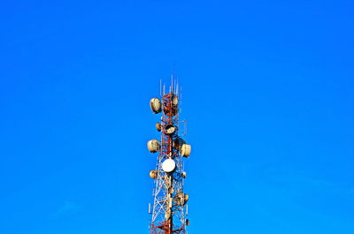 Low angle view of communications tower against blue sky