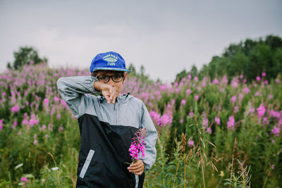 Woman standing on purple flowering plants on field