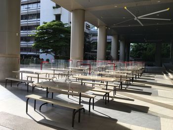 Empty chairs and table against building in city