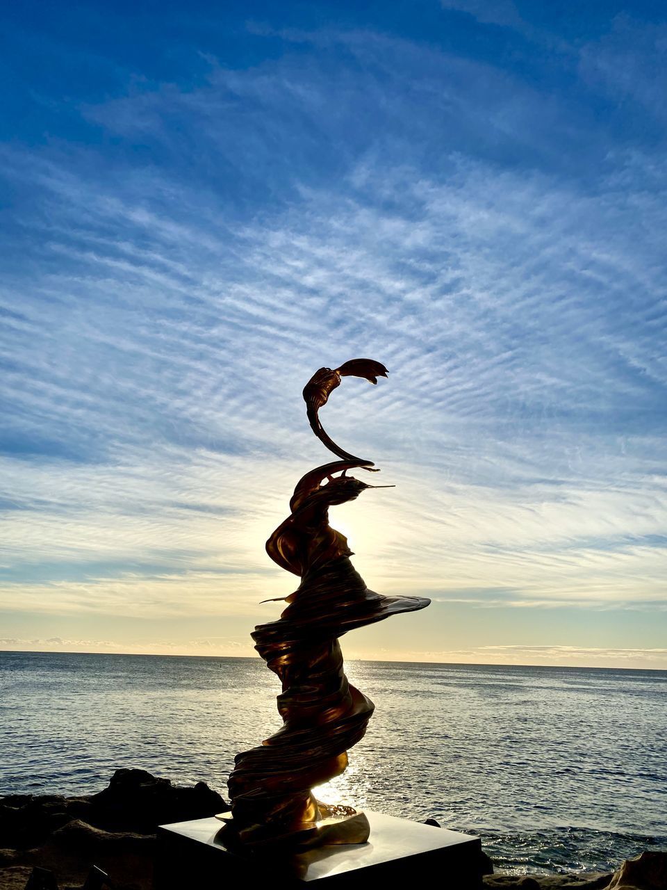 SILHOUETTE ROCK ON BEACH AGAINST SKY