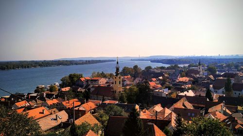 High angle view of townscape by sea against sky