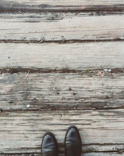 Low section of man standing on wooden floor