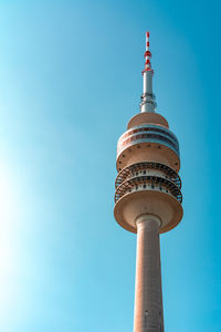 Low angle view of communications tower against sky in city