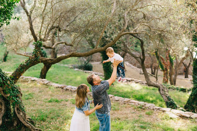 Full length of woman standing by tree