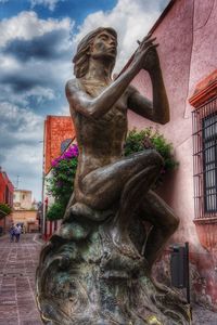 Statue against building in city