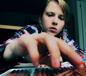 Low angle view of girl looking at colored pencil