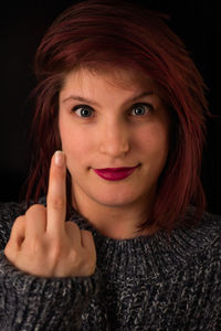 Close-up portrait of a beautiful young woman over black background