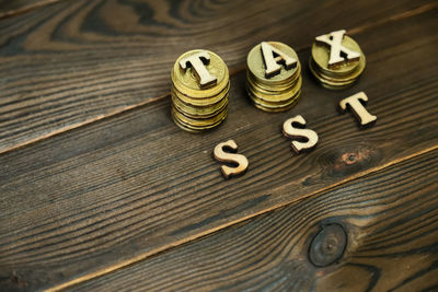 High angle view of coins with tax and sst text on table