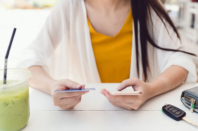 Midsection of woman using mobile phone