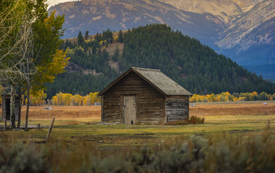 House on field by trees and mountains