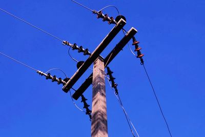 Low angle view of crane against clear blue sky