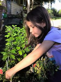 Side view of girl planting at yard