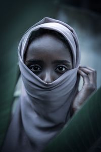 Close-up portrait of a woman covering face