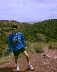 Full length of man wearing sunglasses standing on land against sky