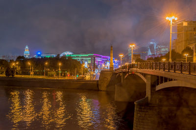 Bridge over moskva river in illuminated city at night