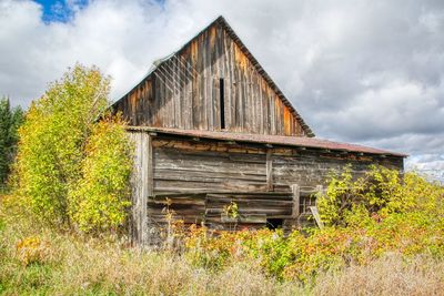 Abandoned building on field against sky