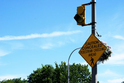 Low angle view of road sign against sky