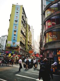 People walking on road along buildings