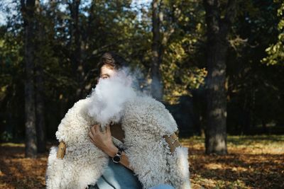 Man smoking while sitting in forest