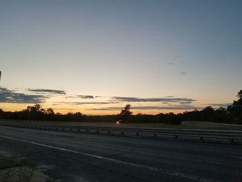 Empty road against sky during sunset