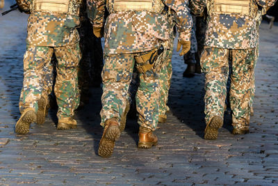 Low section of soldiers walking in parade on footpath