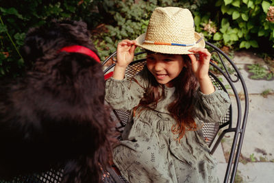 Rear view of girl wearing looking at dog