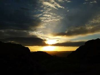 Silhouette of mountain against dramatic sky