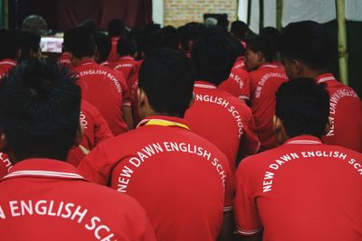 Rear view of boys in red uniform at school