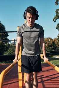 Young man doing dips on parallel bars during his workout in a modern calisthenics street workout