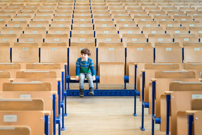 Full length of boy sitting on chair