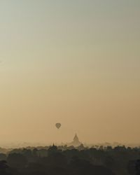 Hot air balloons flying in sky at sunset