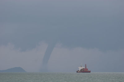 Boat sailing in sea against sky