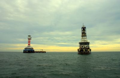 Scenic view of lighthouse by sea against sky