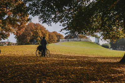 Rear view of people walking on field