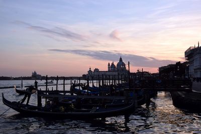 View of gondolas in canal at sunset