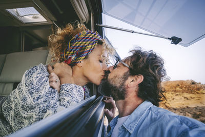 Couple kissing in camping van outdoors