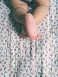 Low section of baby feet on bed