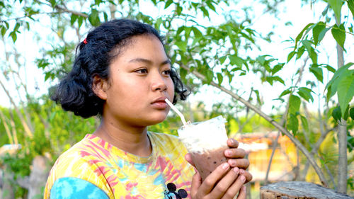 Woman's face, rural thai girl holding a glass of water