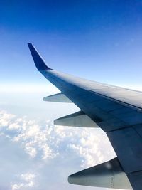 View of airplane wing against blue sky