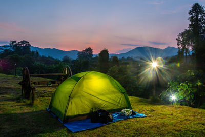 Scenic view of tent on field against sky during sunset