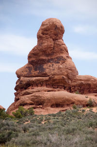 Scenic view of rock formations against cloudy sky