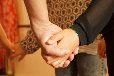 Midsection of couple holding hands