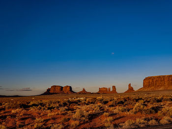 Rock formations on landscape against blue sky