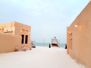 Walkway along built structures with calm sea in background