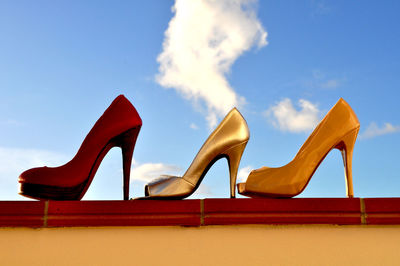 Close-up side view of high heels against sky