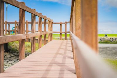 Footbridge over footpath against sky