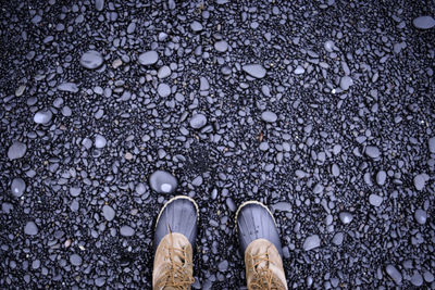 Low section of person standing on pebbles