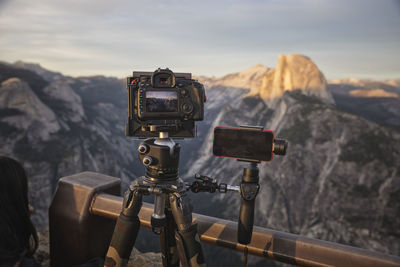 Close-up of camera against mountain range